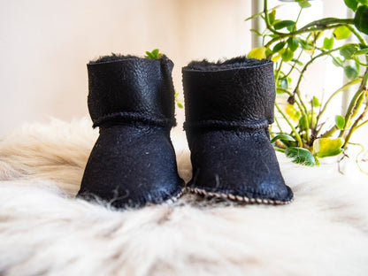 Botas de piel de oveja negra para bebé.
